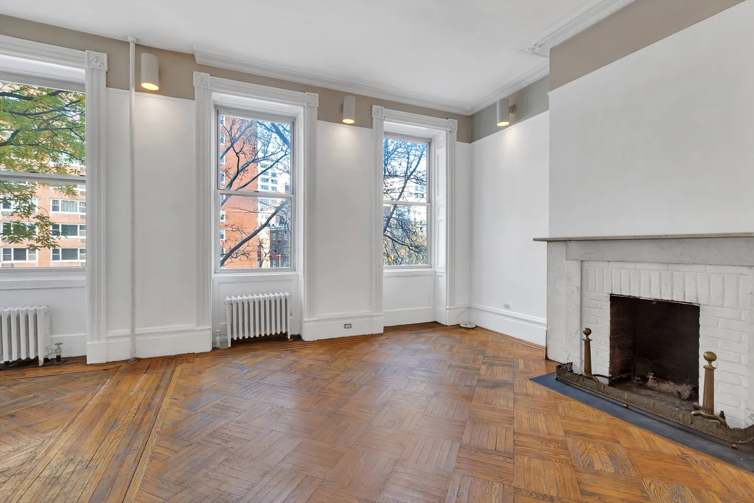 an empty room with windows and fireplace