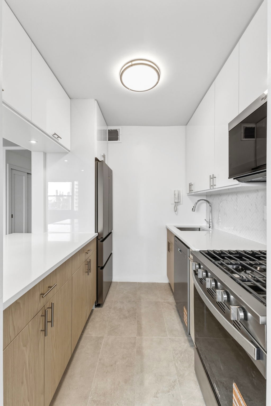 400 East 54th Street, Unit 24E Manhattan, NY 10022 - Photo 8 of 29 a kitchen with stainless steel appliances granite countertop a sink stove and refrigerator