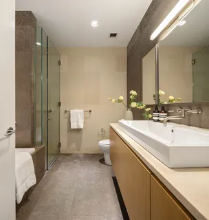 a bathroom with a sink a toilet and shower