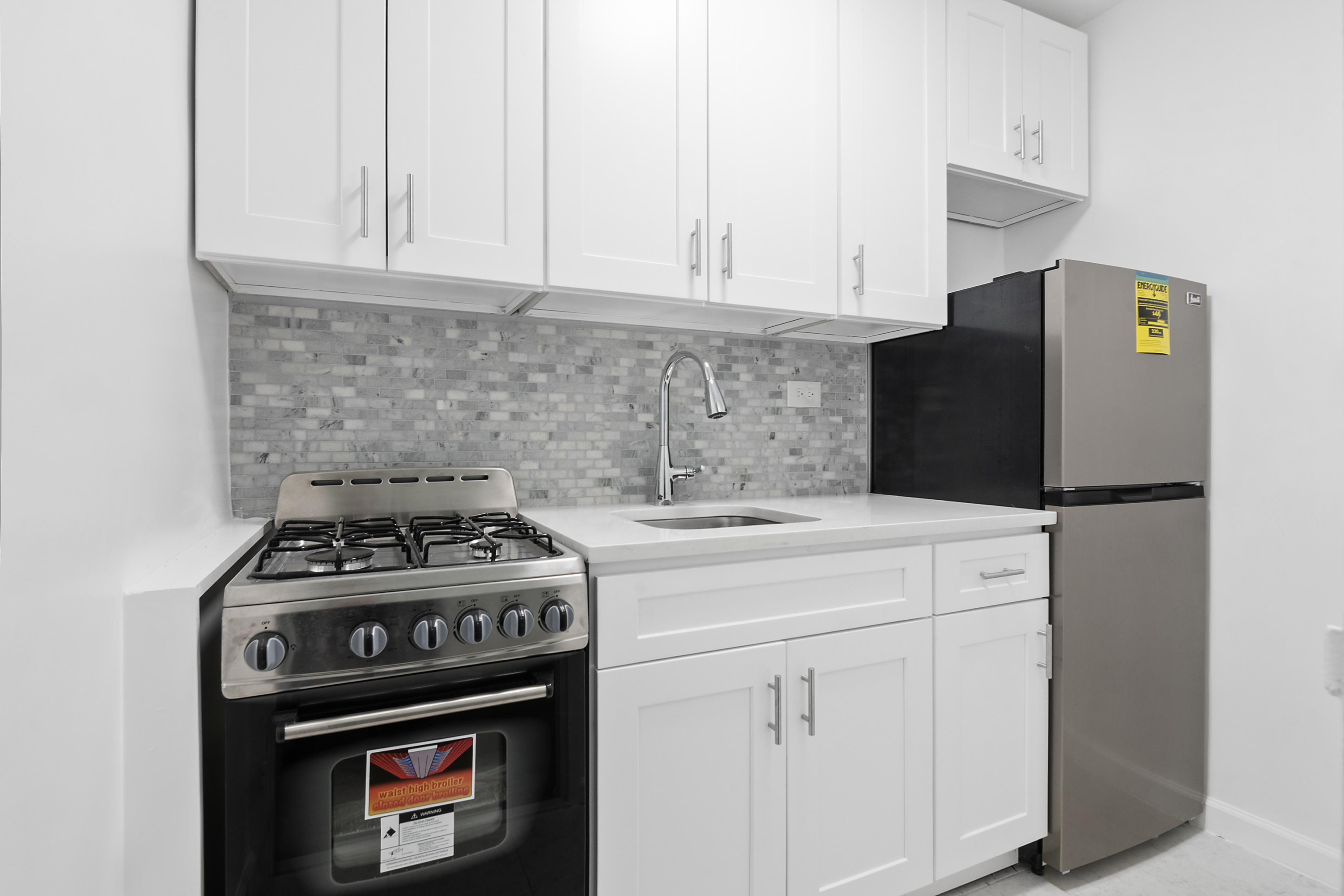 185 Hall Street, Unit 1009 Brooklyn, NY 11205 - Photo 2 of 5 a kitchen with stainless steel appliances granite countertop a stove a refrigerator and a white cabinets
