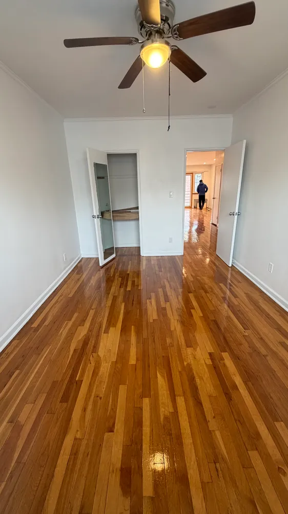 a view of empty room with wooden floor