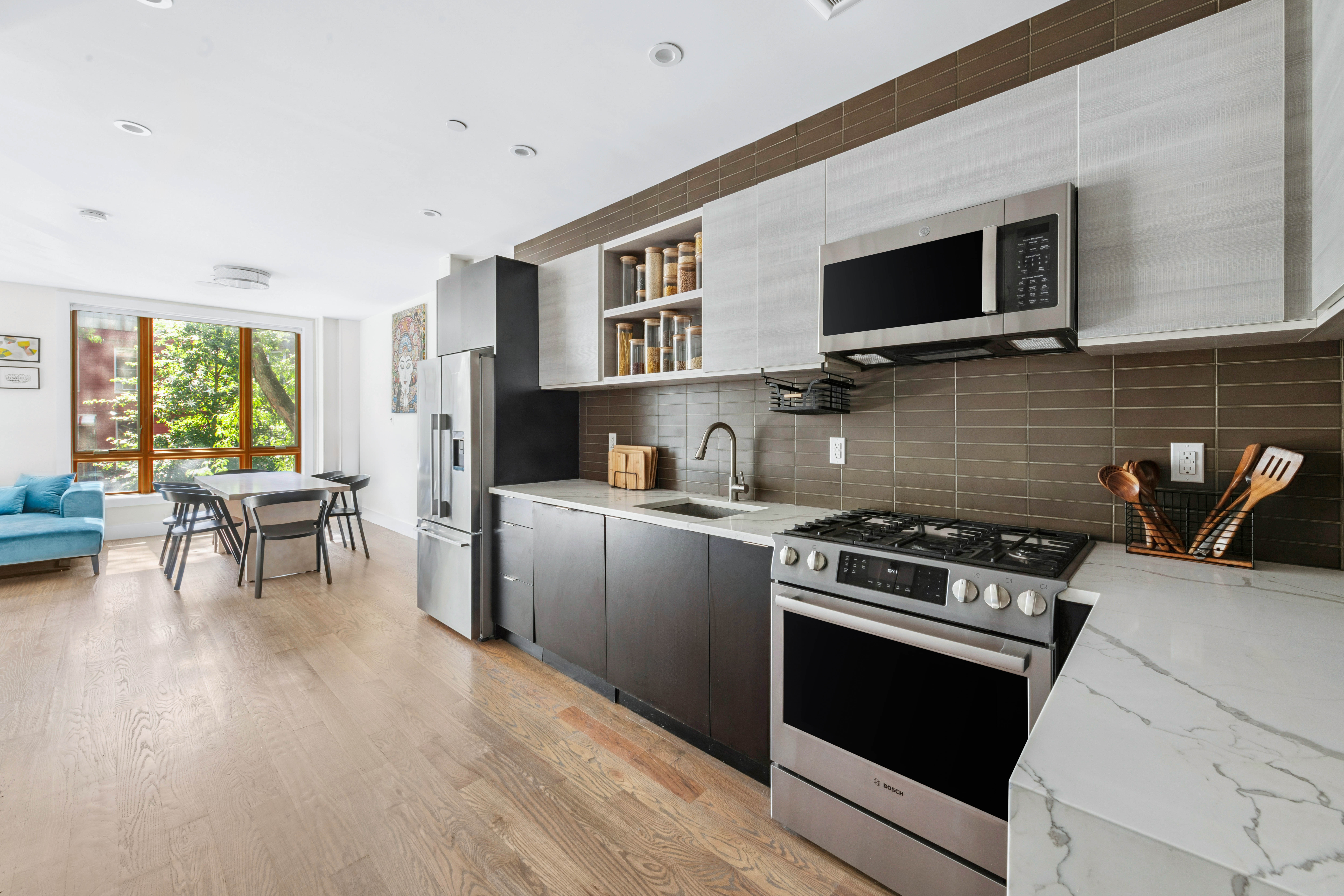 1189 Jefferson Avenue, Unit 2 Brooklyn, NY 11221 - Photo 4 of 10 a kitchen with stainless steel appliances a stove a microwave and white cabinets