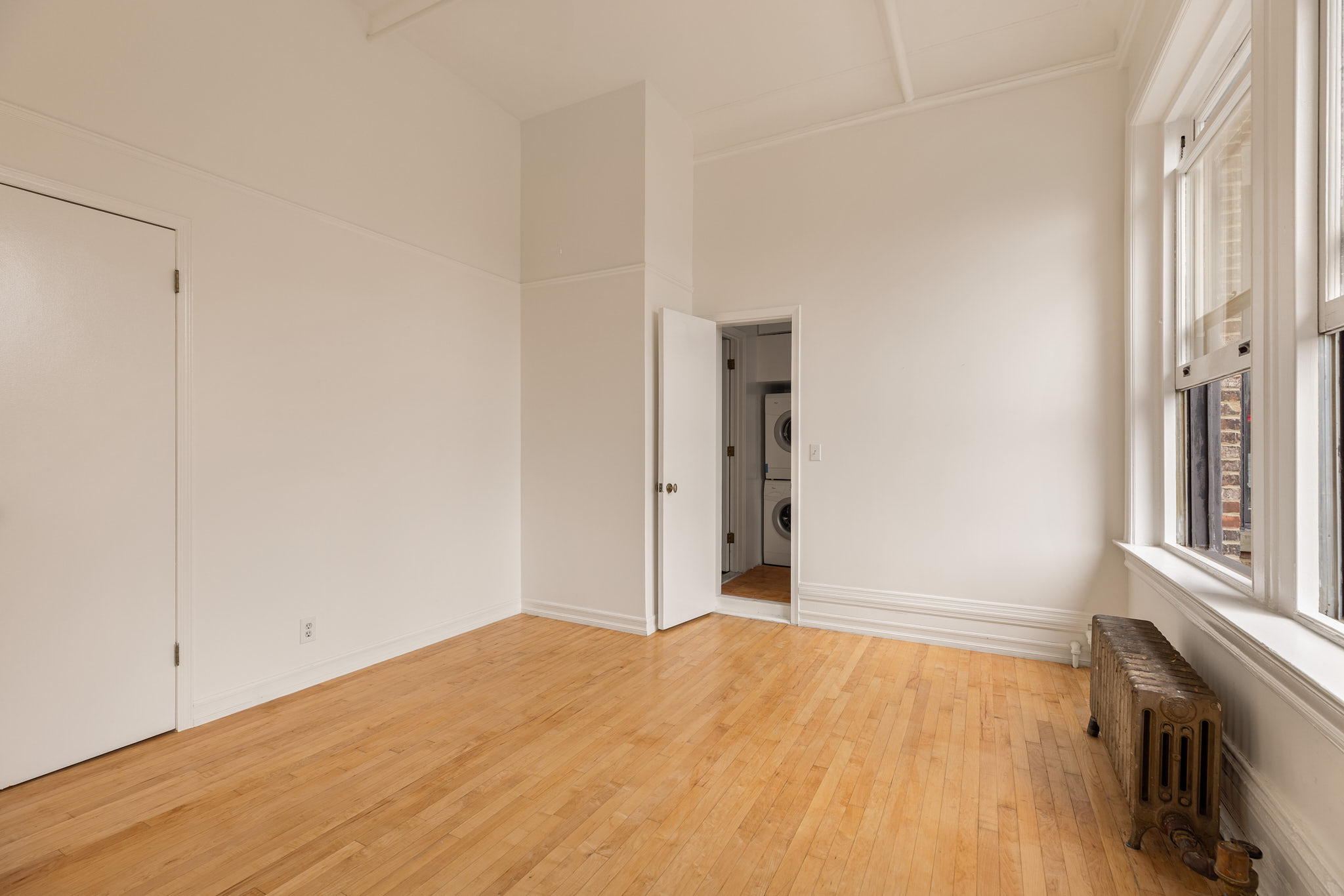 874 Broadway, Unit 907 Manhattan, NY 10003 - Photo 7 of 22 a view of an empty room with wooden floor and a window