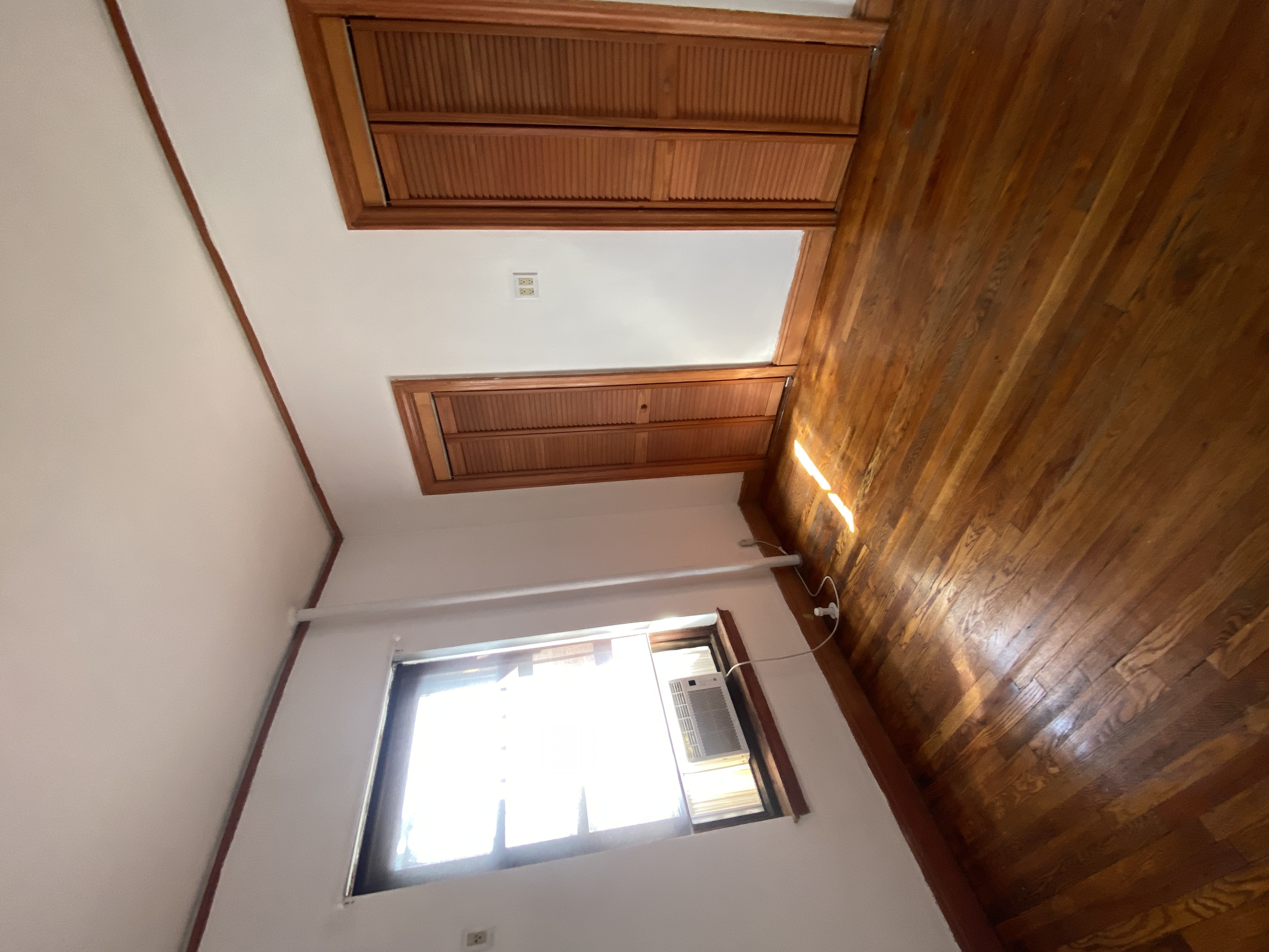 94 Hamilton Place, Unit 5E Manhattan, NY 10031 - Photo 6 of 13 an empty room with wooden floor and windows