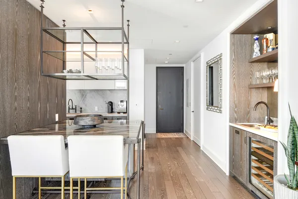 a kitchen with stainless steel appliances granite countertop a stove a sink and a refrigerator with wooden floor