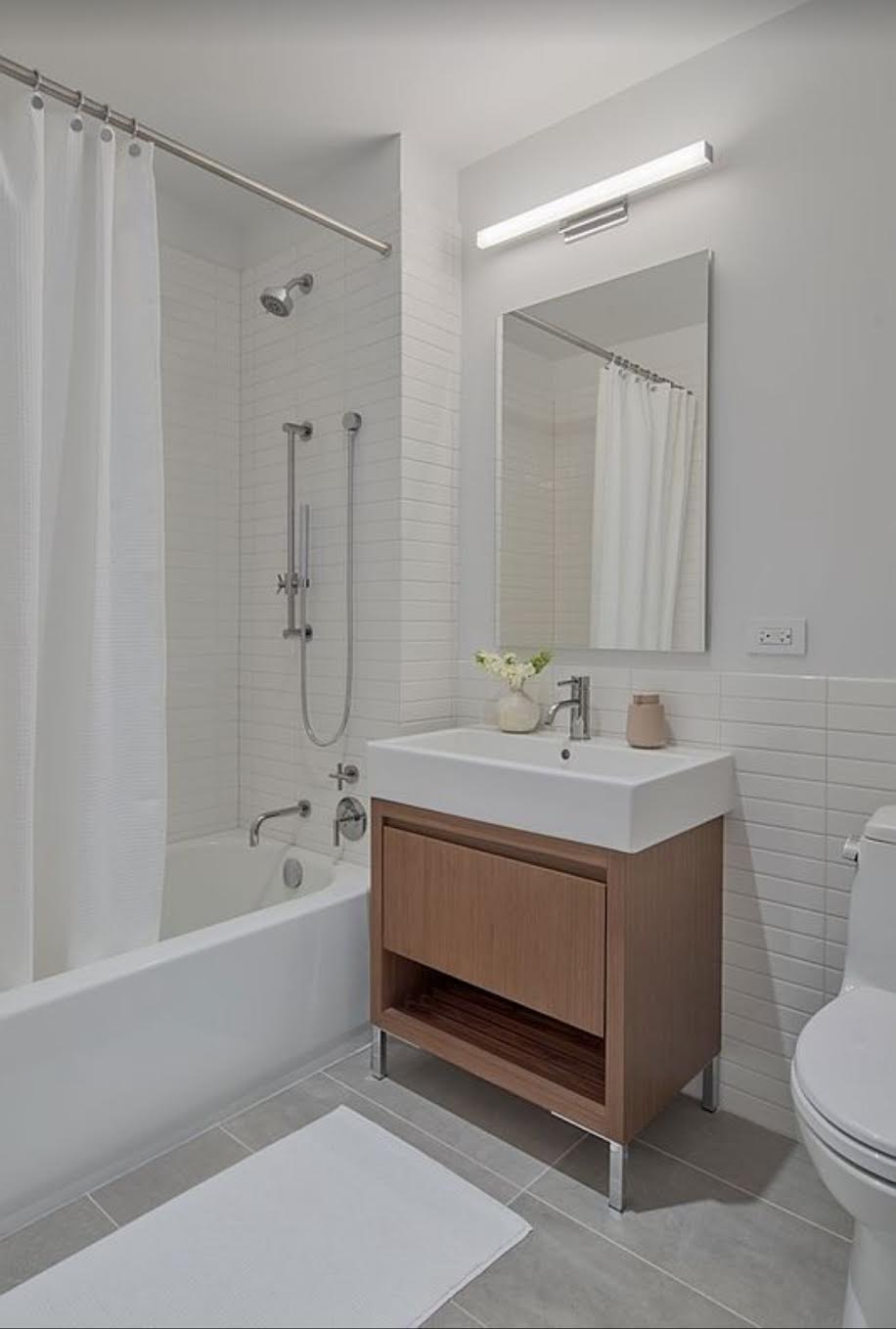 5 South 5th Street, Unit 308 Brooklyn, NY 11249 - Photo 6 of 13 a bathroom with a sink a toilet and shower