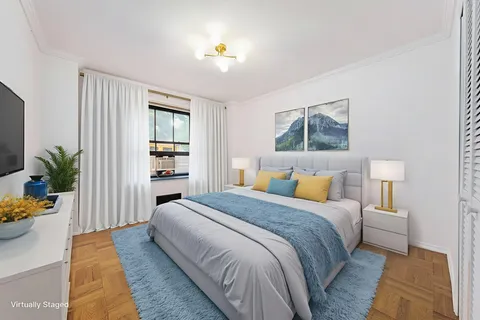 a spacious bedroom with a bed and a potted plant