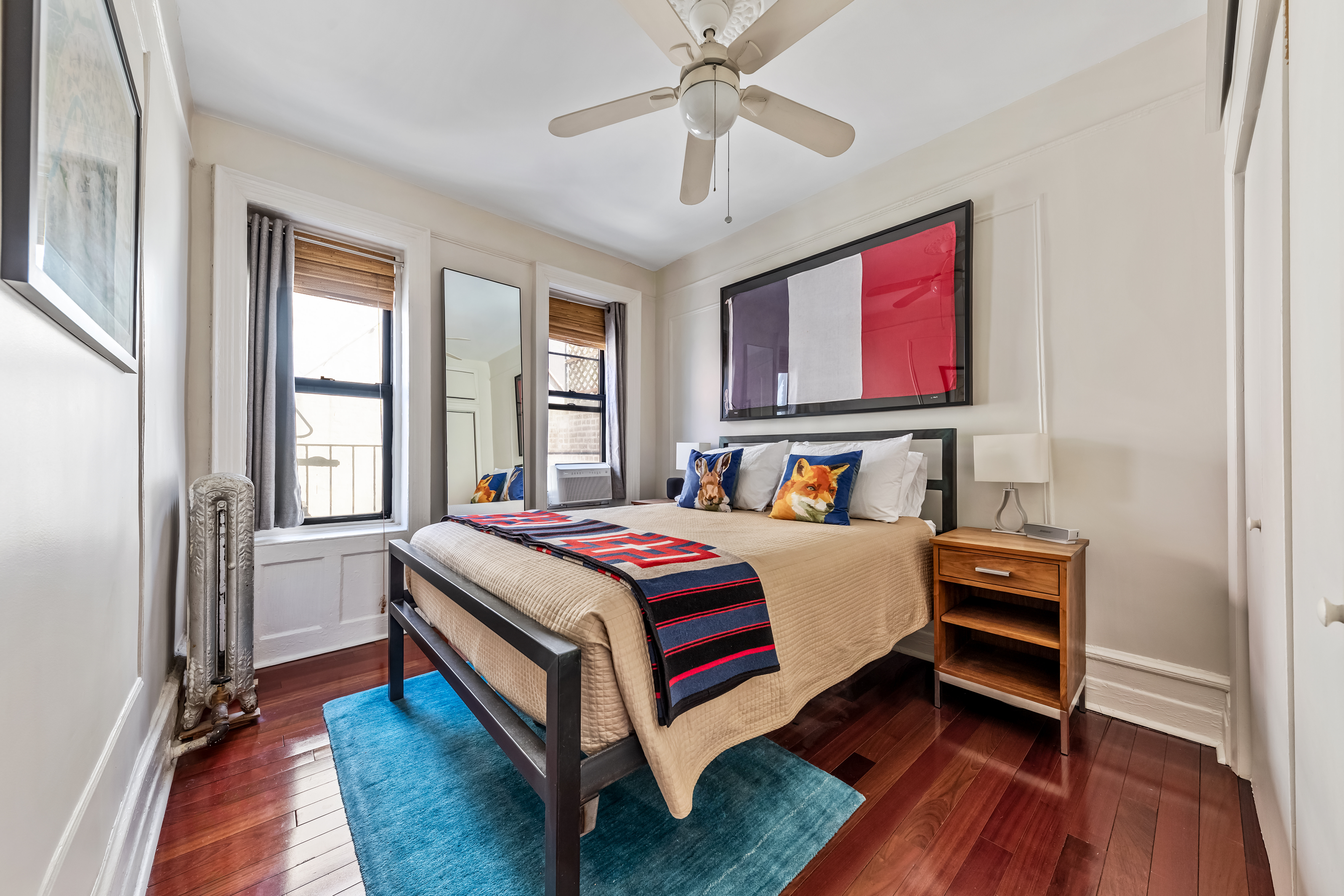 411 West 44th Street, Unit 13 Manhattan, NY 10036 - Photo 2 of 8 a bedroom with a bed and wooden floor