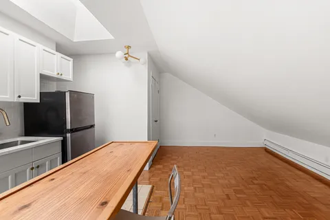 a bedroom with a bed and a refrigerator