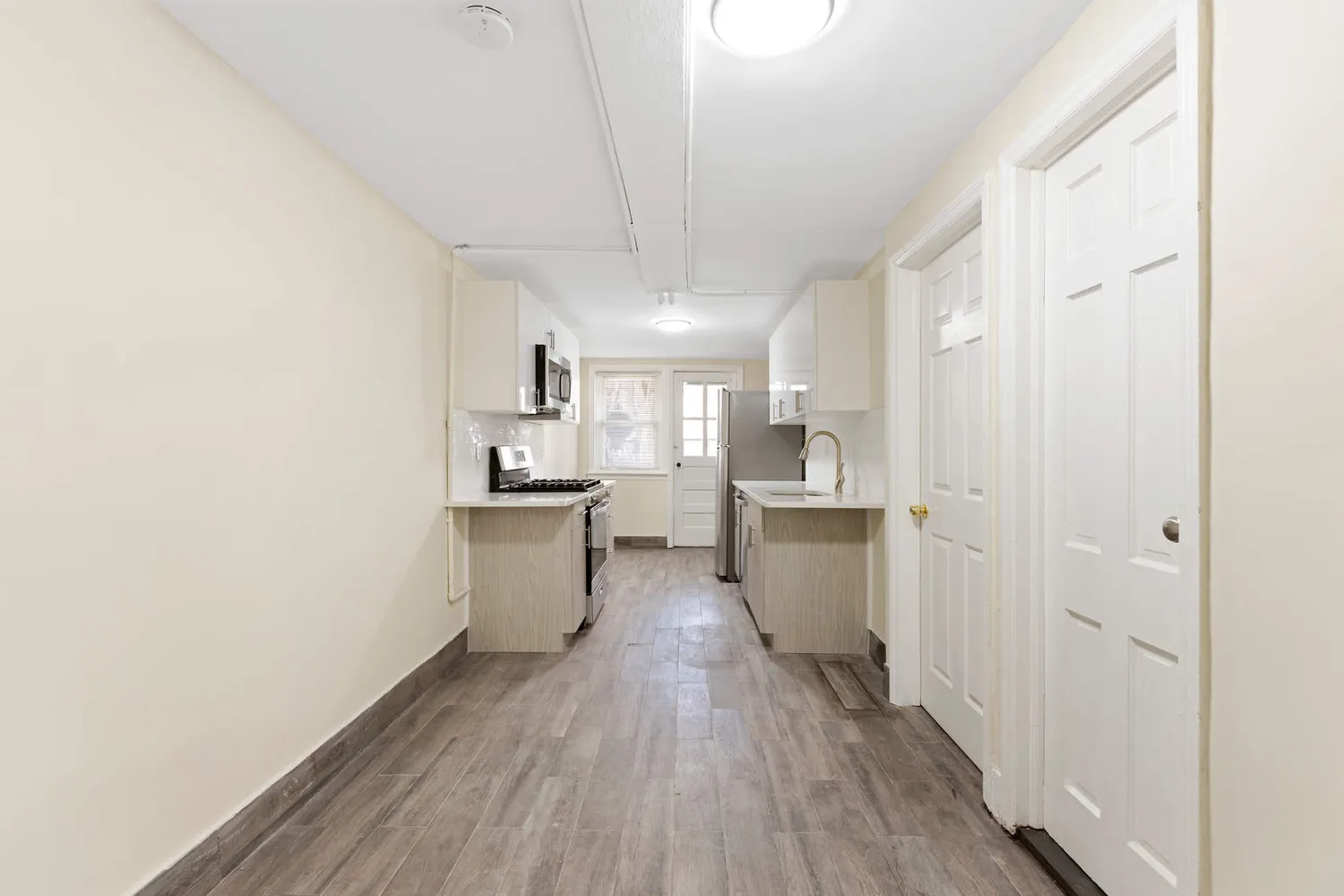 a kitchen with a refrigerator and white cabinets