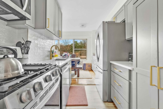 135 Ashland Place, Unit 5A Brooklyn, NY 11201 - Photo 4 of 12 a kitchen with stainless steel appliances granite countertop a stove and a refrigerator