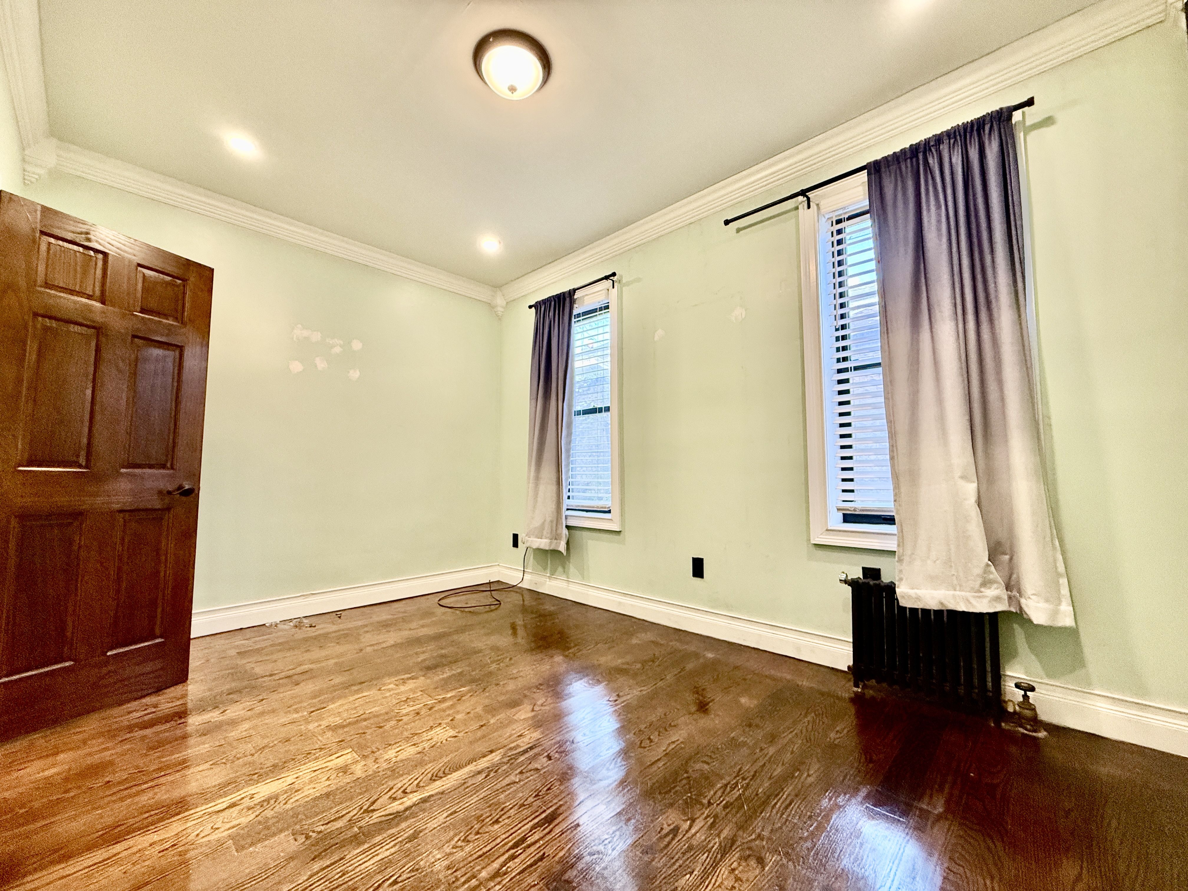6817 Owls Head Court, Unit 1B Brooklyn, NY 11220 - Photo 4 of 6 a view of an empty room with wooden floor and a window