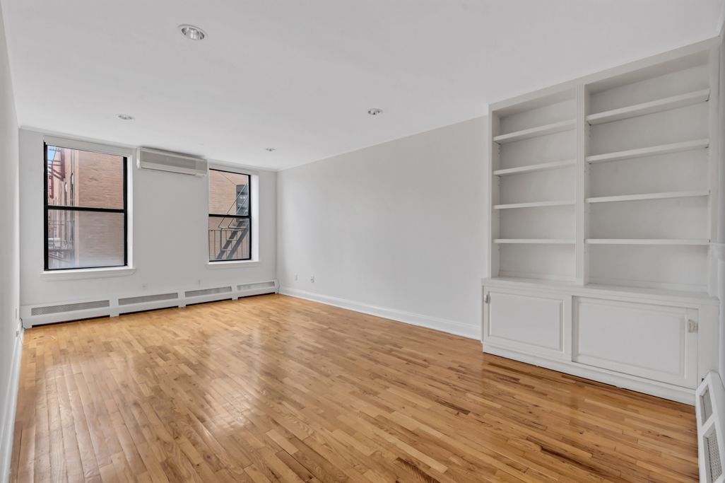 2098 Frederick Douglass Boulevard, Unit 5E Manhattan, NY 10026 - Photo 1 of 8 a view of an empty room with a window and wooden floor