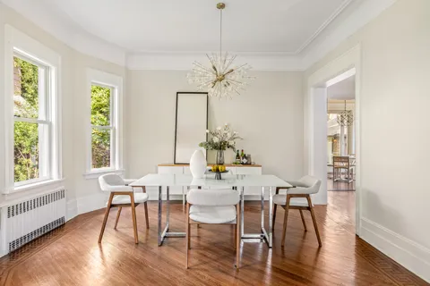 a dining room with furniture a chandelier and wooden floor