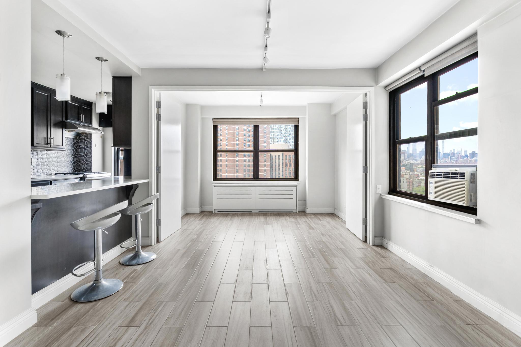 266 East Broadway, Unit 1304B Manhattan, NY 10002 - Photo 2 of 8 wooden floor in an empty room with a window
