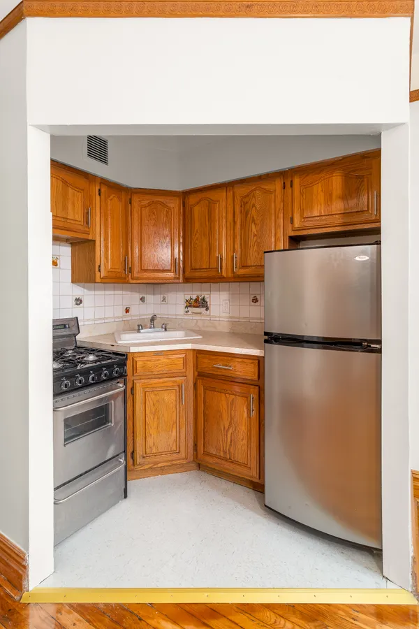 a kitchen with granite countertop a refrigerator stove top oven and sink