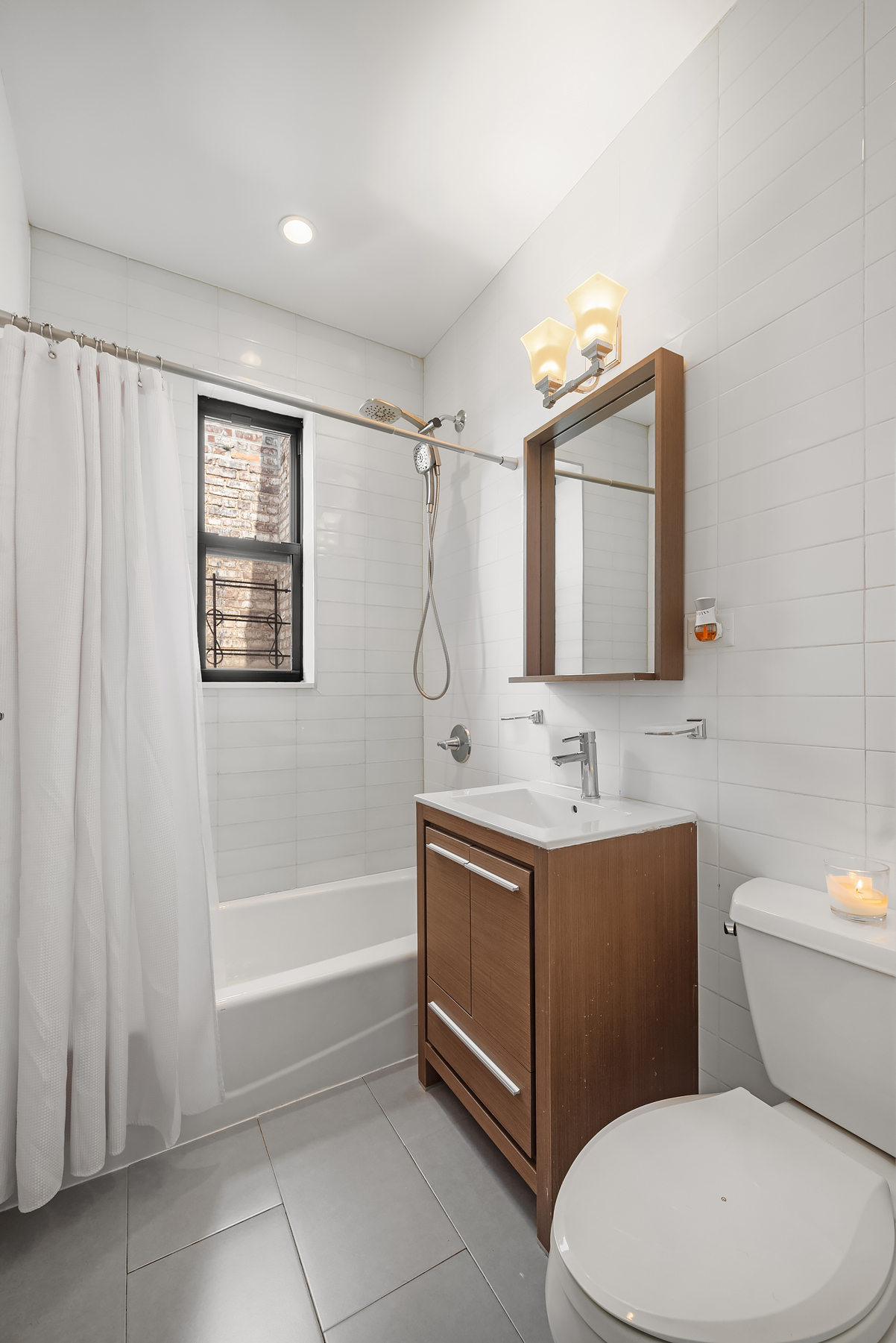 750 Riverside Drive, Unit 6B Manhattan, NY 10031 - Photo 4 of 8 a bathroom with a toilet sink and mirror