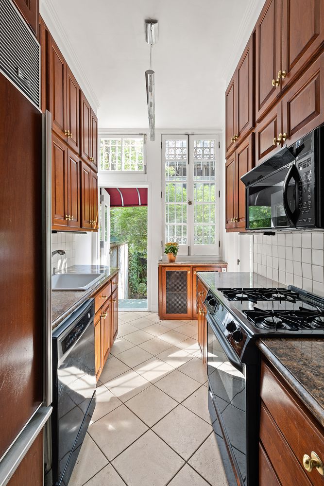 20 West 9th Street, Unit DUPLEX Manhattan, NY 10011 - Photo 3 of 10 a kitchen with stainless steel appliances granite countertop a stove a sink and a refrigerator