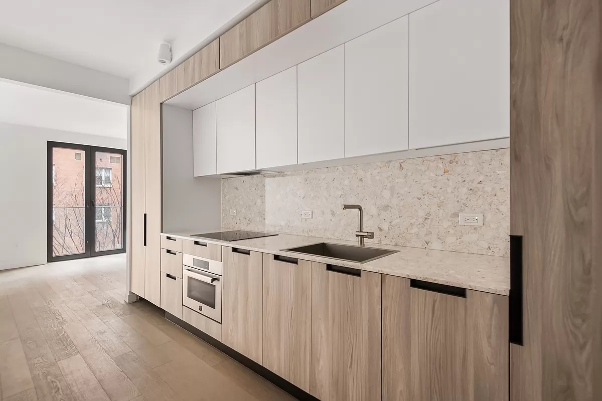 181 East 101st Street, Unit 507 Manhattan, NY 10029 - Photo 3 of 10 a kitchen with granite countertop white cabinets and white appliances