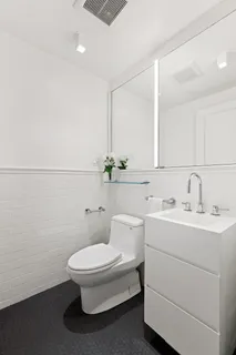 a bathroom with a toilet a sink and mirror