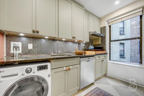 a kitchen with stainless steel appliances granite countertop a sink a stove and cabinets
