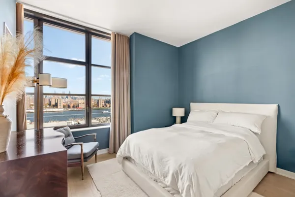 a large bed sitting in a bedroom next to a large window