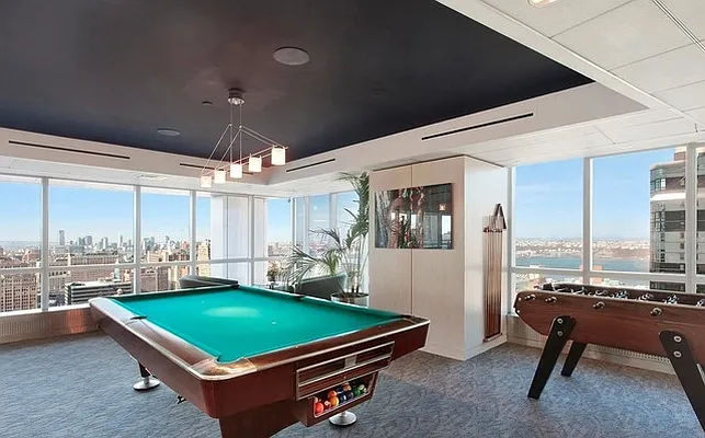 350 West 42nd Street, Unit 20G Manhattan, NY 10036 - Photo 23 of 27 a room with pool table and windows