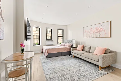 a spacious bedroom with a bed a couch and a window