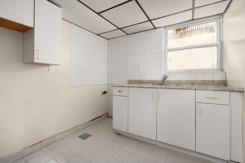 a bathroom with a granite countertop sink and white cabinets