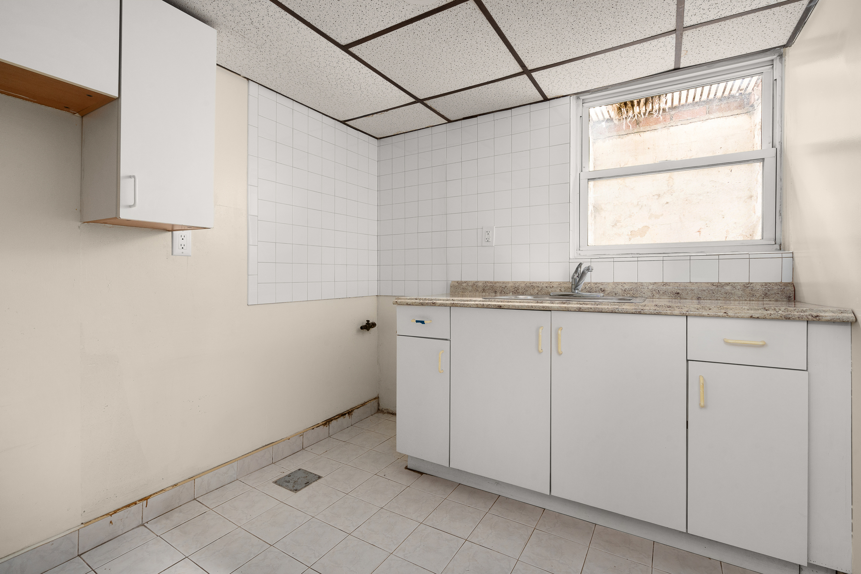 1268 East 52nd Street Brooklyn, NY 11234 - Photo 12 of 13 a bathroom with a granite countertop sink and white cabinets