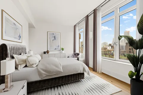 a bedroom with a large bed and a potted plant