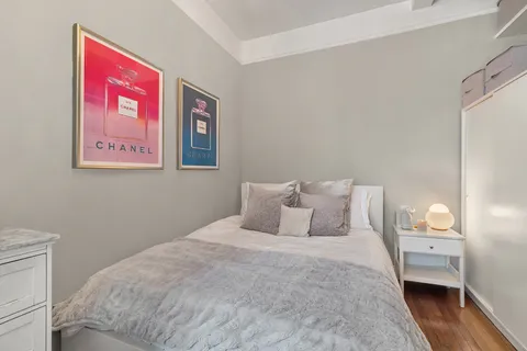 a bedroom with a bed and wooden floor