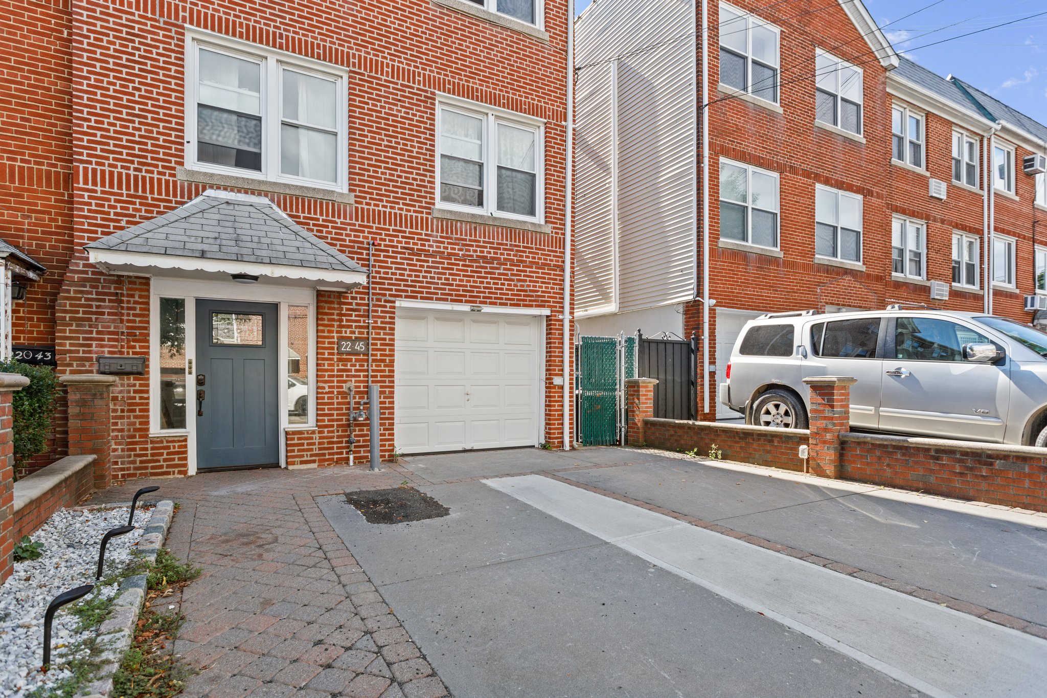 22-45 47th Street, Unit 3 Queens, NY 11105 - Photo 14 of 14 a front view of a residential apartment building with a yard