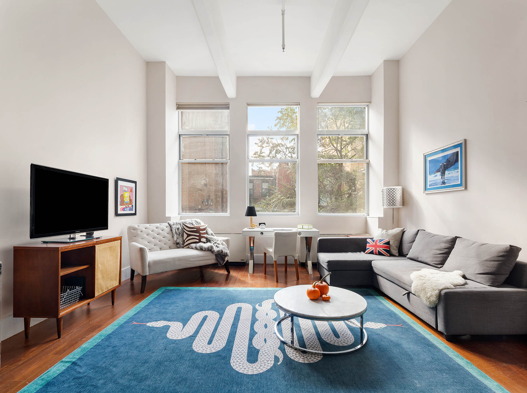 60 Broadway, Unit 2P Brooklyn, NY 11249 - Photo 4 of 8 a living room with furniture a flat screen tv and a large window