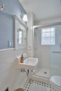 a bathroom with a sink a toilet and shower