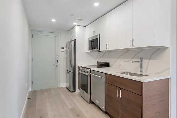 605 Hart Street, Unit 406 Brooklyn, NY 11221 - Photo 3 of 10 a kitchen with a sink a refrigerator and cabinets