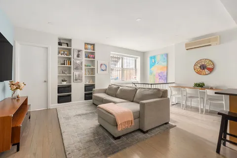 a living room with furniture and a book shelf