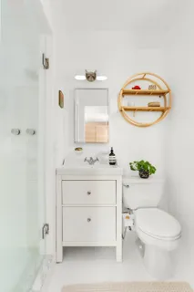 a bathroom with a toilet a sink and mirror
