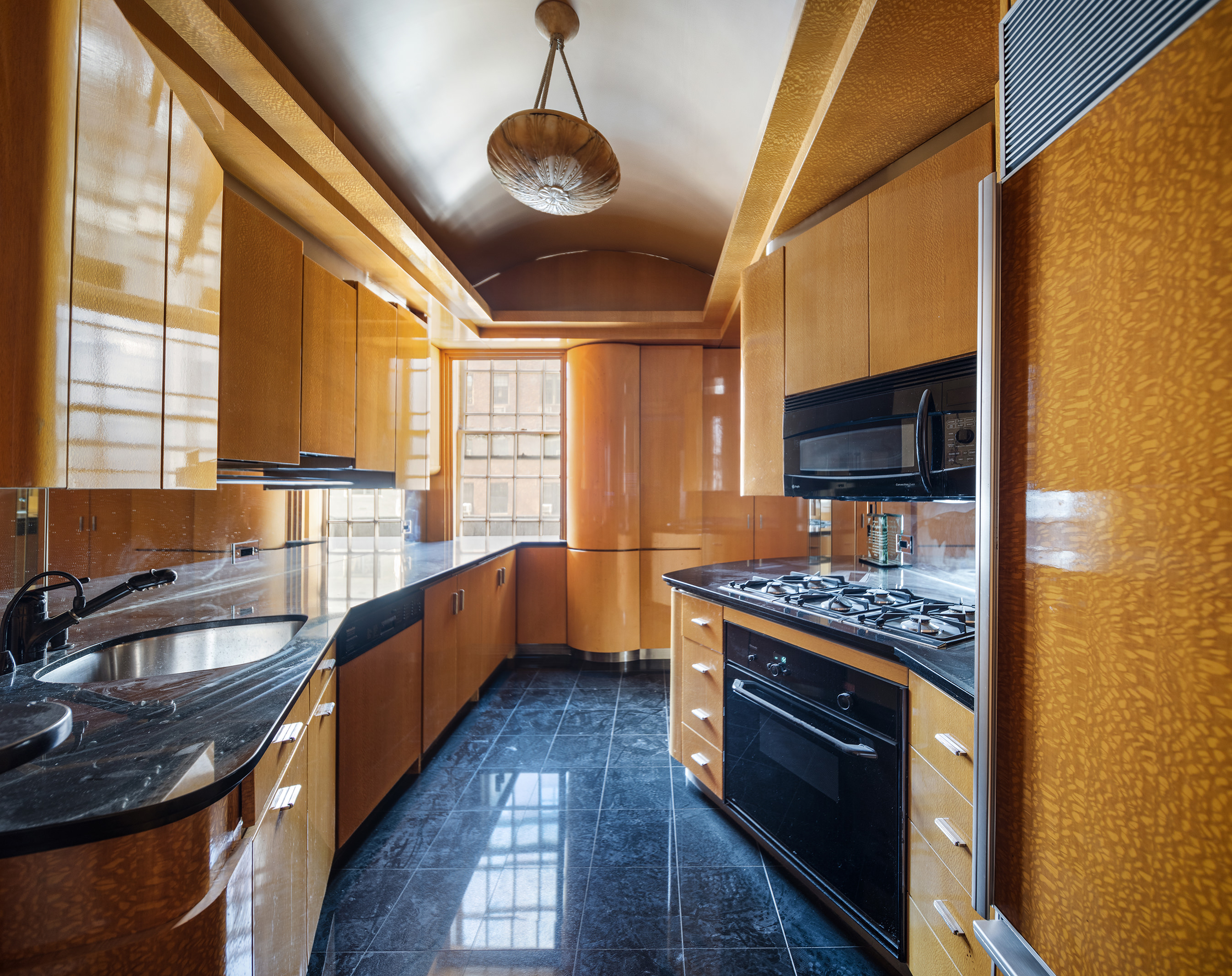 45 East 66th Street, Unit 4NW Manhattan, NY 10065 - Photo 19 of 29 a kitchen with stainless steel appliances granite countertop a sink a stove and a wooden floors