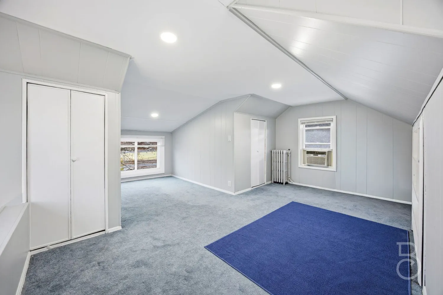 an empty room with windows and closet