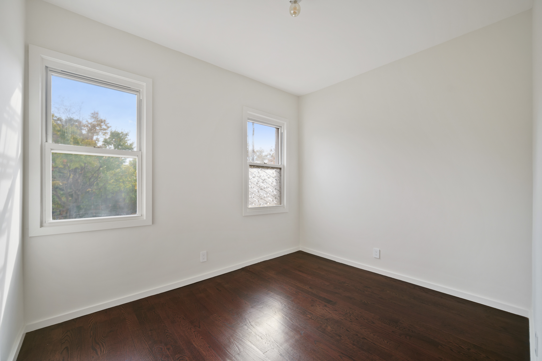 441 Metropolitan Avenue, Unit 1 Brooklyn, NY 11211 - Photo 7 of 11 a view of an empty room with wooden floor and a window
