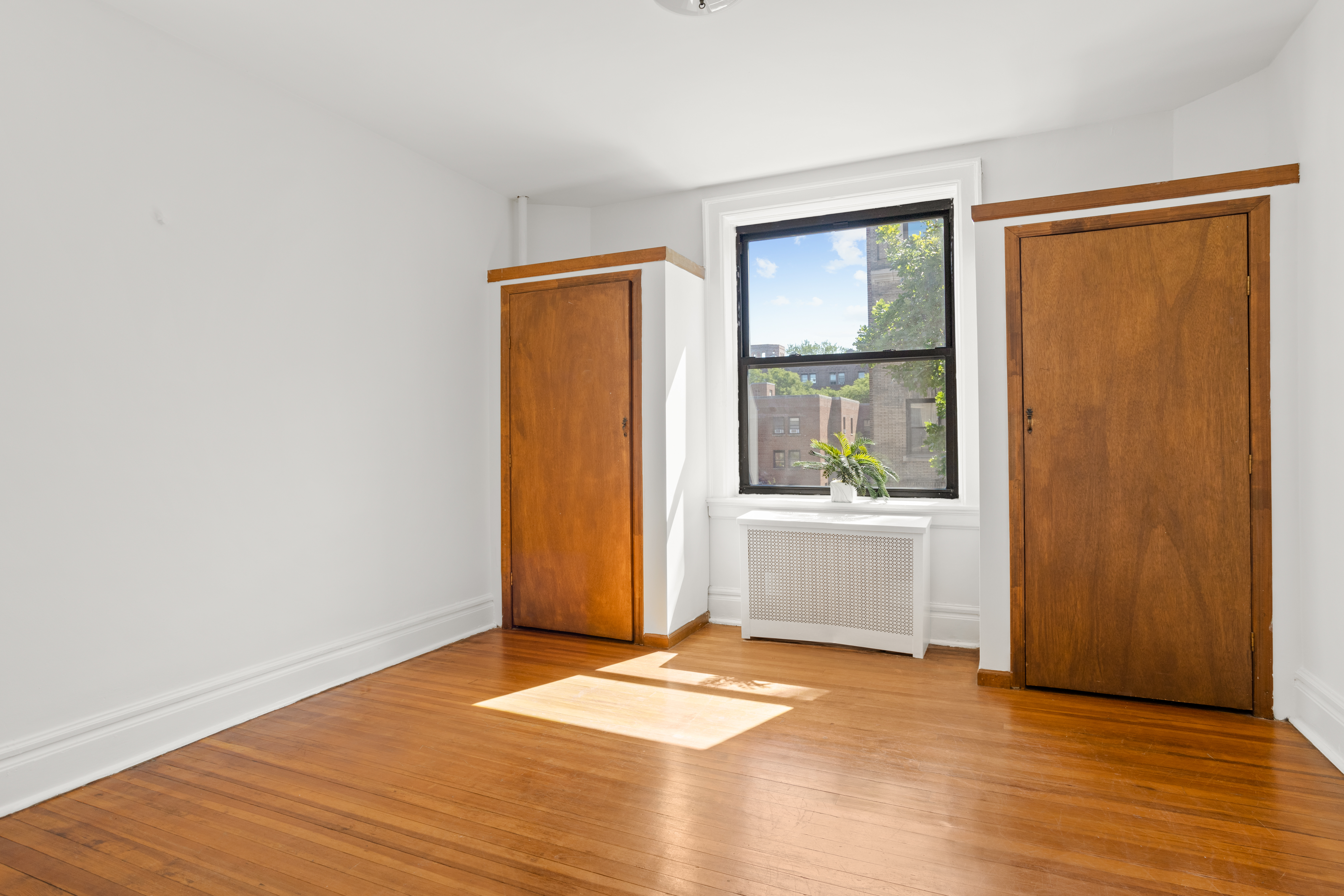 35-30 82nd Street, Unit 32 Queens, NY 11372 - Photo 4 of 11 a view of an empty room with wooden floor and a window