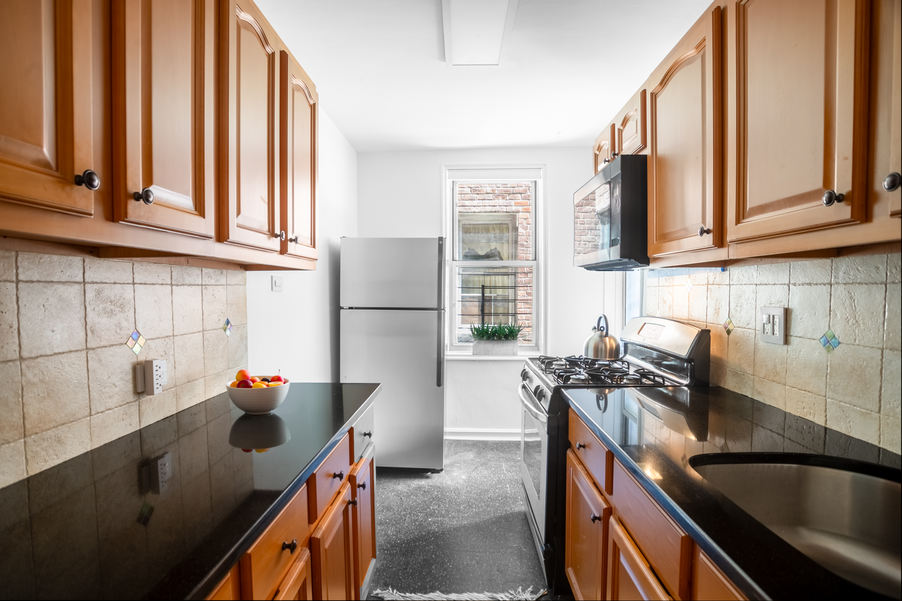 340 Haven Avenue, Unit 2H Manhattan, NY 10033 - Photo 3 of 24 a kitchen with stainless steel appliances a sink a stove and a refrigerator
