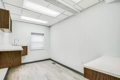 a view of a kitchen with wooden floor and electronic appliances