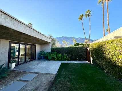 a view of a backyard with brick wall and potted plants