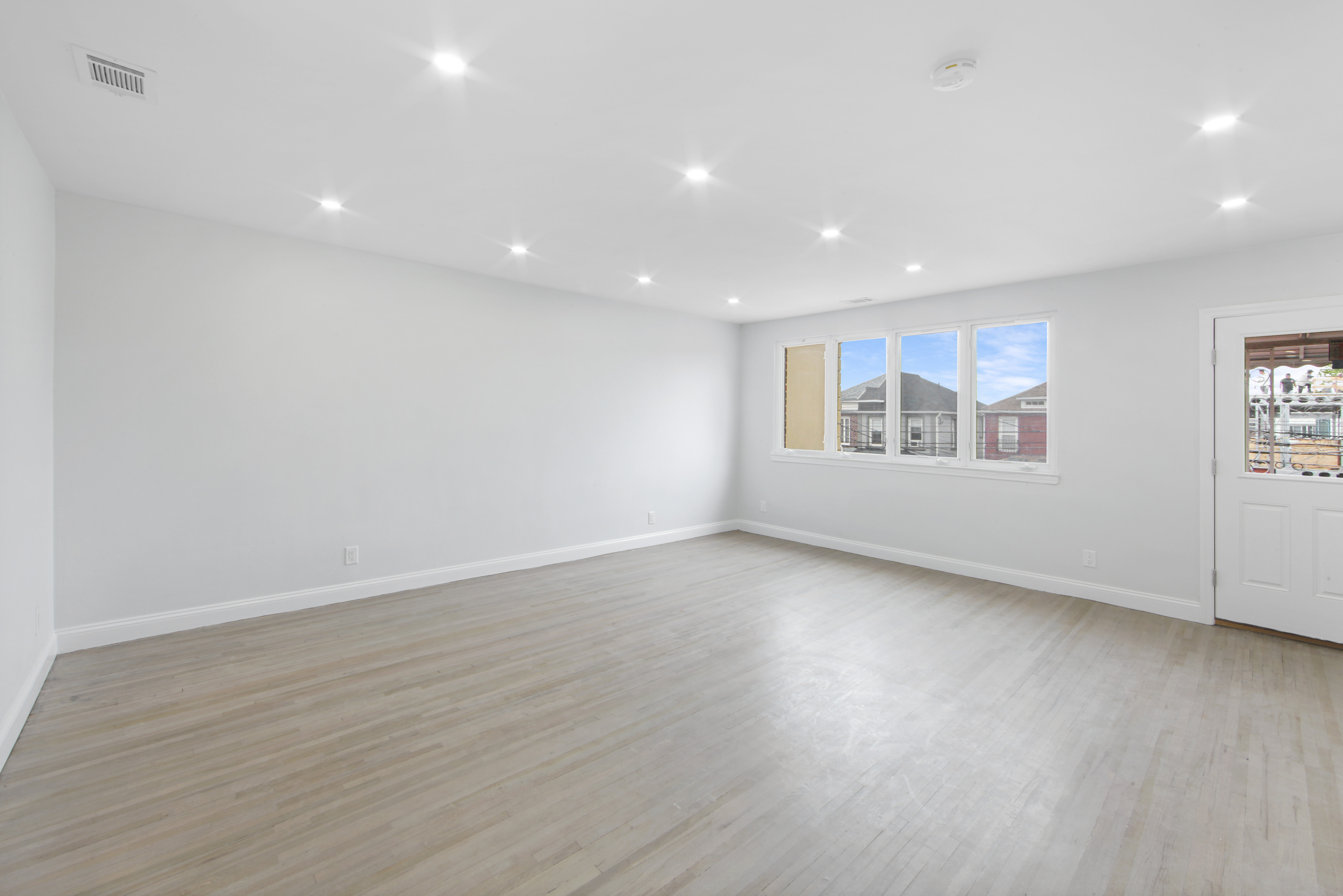 2345 East 1st Street, Unit 2 Brooklyn, NY 11223 - Photo 2 of 10 an empty room with wooden floor and windows