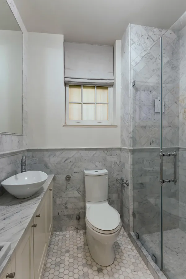 a bathroom with a granite countertop toilet a sink and a shower