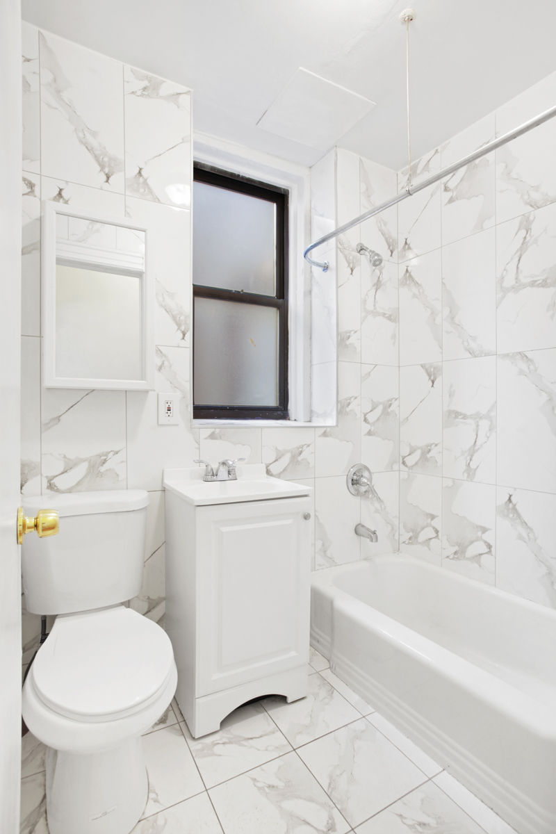 155 Garfield Place, Unit 3B Brooklyn, NY 11215 - Photo 4 of 6 a bathroom with a toilet sink and mirror