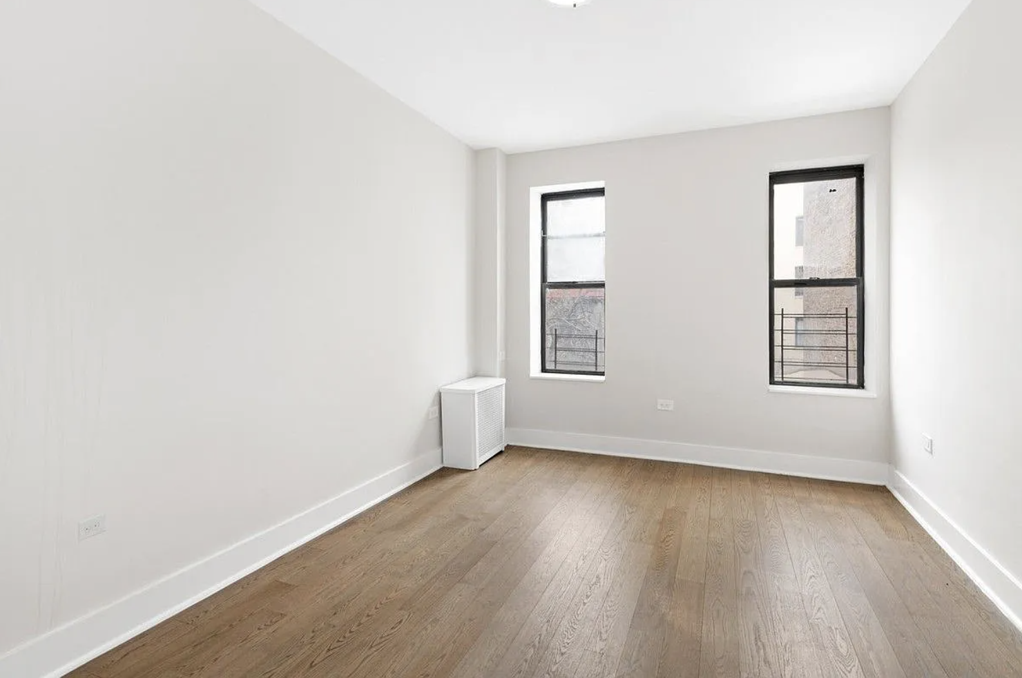 601 Crown Street, Unit C3 Brooklyn, NY 11213 - Photo 4 of 9 an empty room with wooden floor and windows