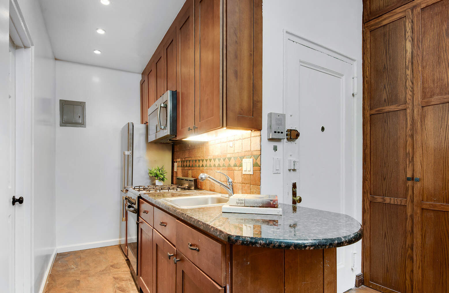310 West 98th Street, Unit 1B Manhattan, NY 10025 - Photo 5 of 11 a bathroom with a granite countertop sink and a mirror